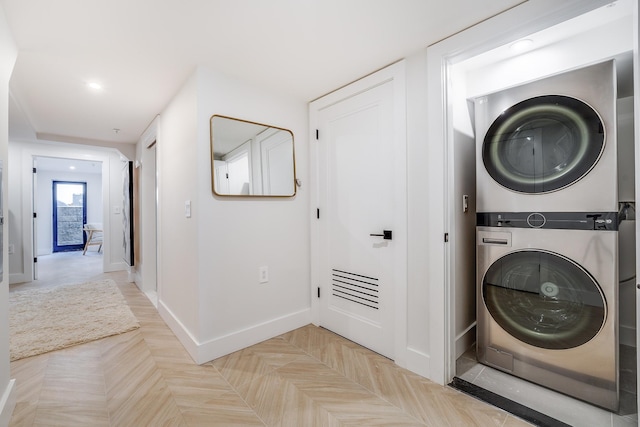 laundry area featuring laundry area, recessed lighting, stacked washer and dryer, and baseboards