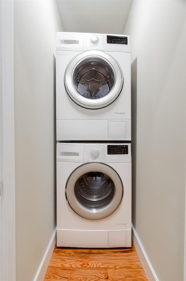 275 Pearsall Ave Unit 2, Jersey City, NJ 07305 - laundry area featuring stacked washer and dryer, baseboards, light wood-style floors, and laundry area