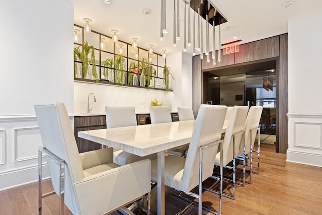 88 Morgan St Unit 2206, Jersey City, NJ 07302 - dining space featuring a decorative wall, wood finished floors, and a wainscoted wall