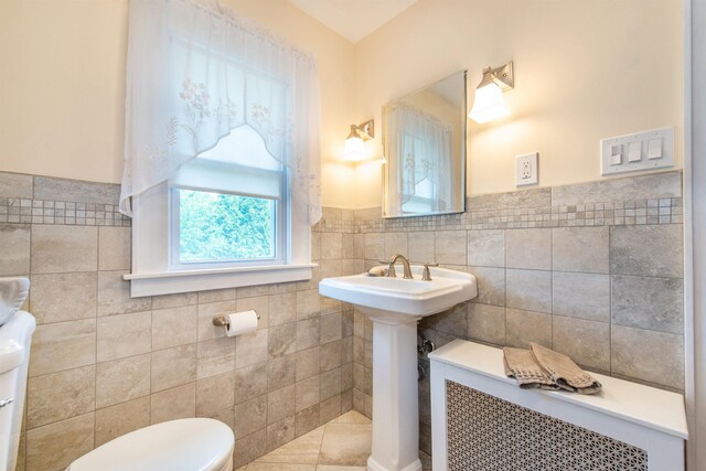 532 Passaic Ave, Nutley, NJ 07110 - half bath featuring tile walls, toilet, a wainscoted wall, a sink, and tile patterned floors