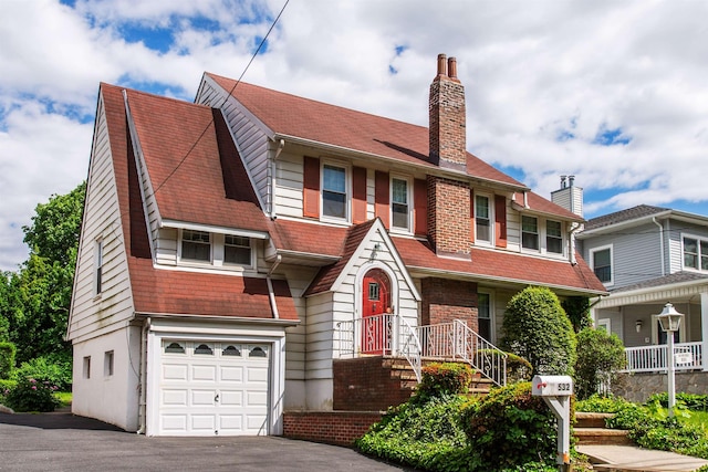 532 Passaic Ave, Nutley, NJ 07110 - view of front facade with a chimney, asphalt driveway, and a garage