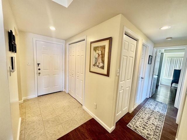 corridor featuring light tile patterned floors, baseboards, and recessed lighting