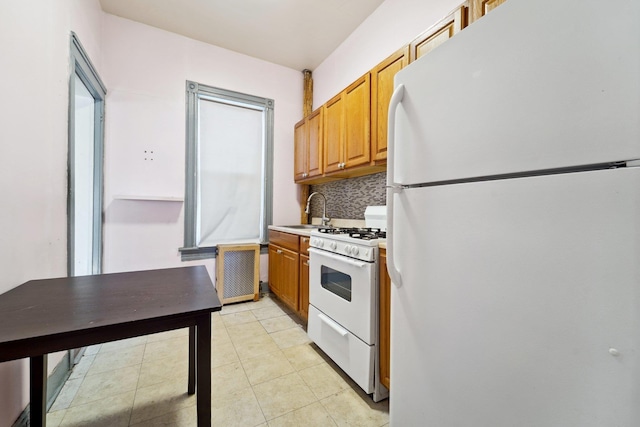 kitchen featuring sink, white appliances, light tile patterned floors, and tasteful backsplash