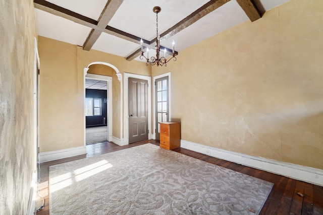 unfurnished dining area with coffered ceiling, hardwood / wood-style flooring, beam ceiling, and an inviting chandelier