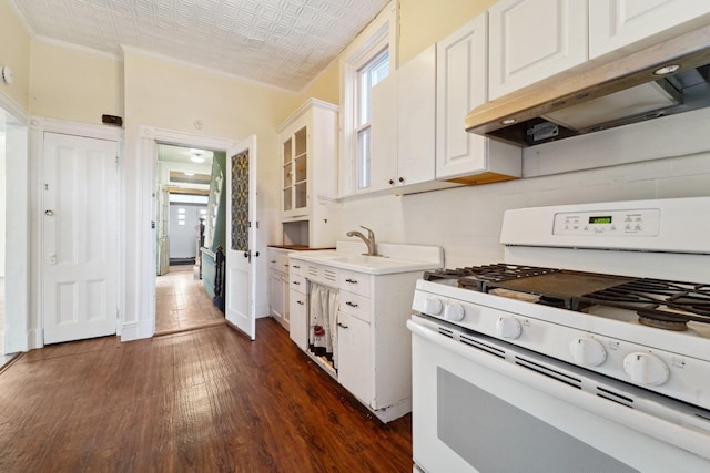 kitchen featuring dark hardwood / wood-style flooring, sink, white cabinetry, ornamental molding, and white gas stove