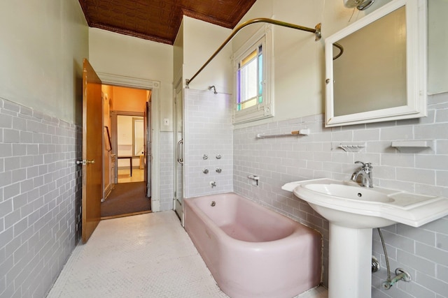 bathroom with tile patterned floors, washtub / shower combination, tile walls, and wooden ceiling