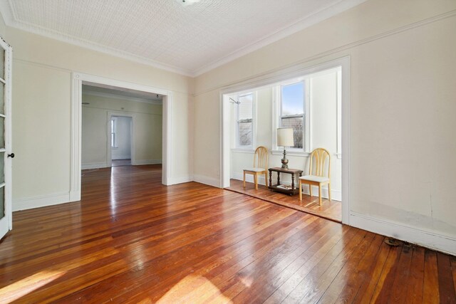 spare room featuring ornamental molding and hardwood / wood-style floors