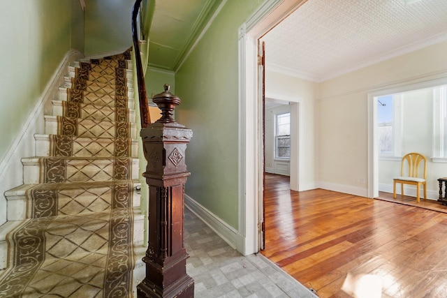 stairs with wood-type flooring and ornamental molding