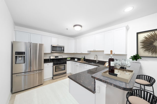 650 2nd St Unit 3C, Hoboken, NJ 07030 - kitchen with stainless steel appliances, a peninsula, white cabinets, a breakfast bar area, and recessed lighting