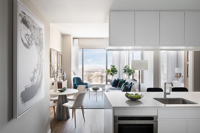 kitchen with white cabinetry, hardwood / wood-style floors, and sink