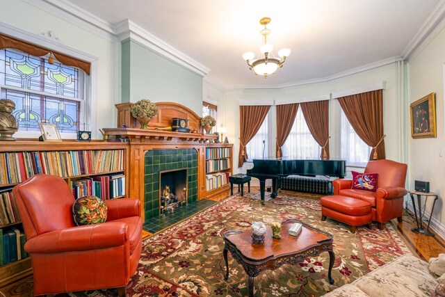 895 Summit Ave, Jersey City, NJ 07307 - living area with ornamental molding, a chandelier, a fireplace, wood finished floors, and baseboards