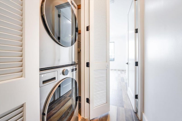 clothes washing area with stacked washer and dryer and light hardwood / wood-style floors