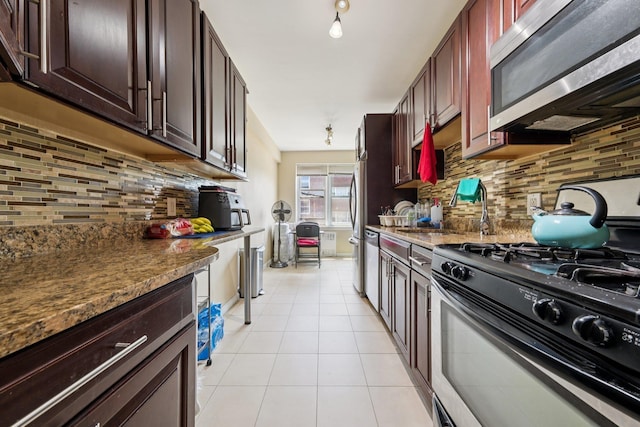 2520 Kennedy Blvd Unit 4C, Jersey City, NJ 07304 - kitchen with stainless steel appliances, decorative backsplash, light tile patterned floors, a sink, and dark stone countertops