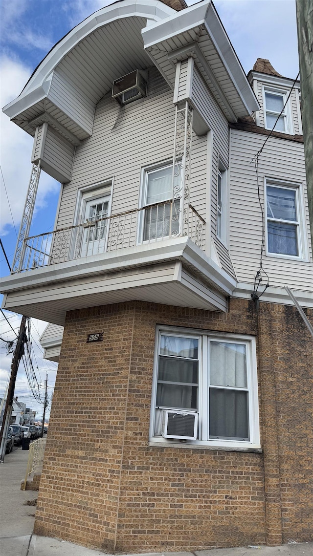 view of home's exterior with cooling unit and a balcony