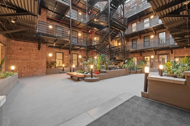 building lobby featuring a towering ceiling and brick wall