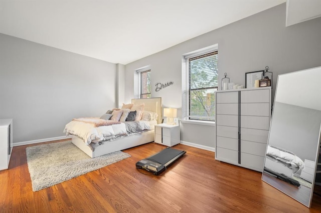 bedroom featuring wood finished floors and baseboards