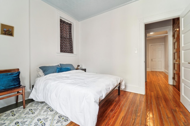 bedroom featuring baseboards and hardwood / wood-style flooring