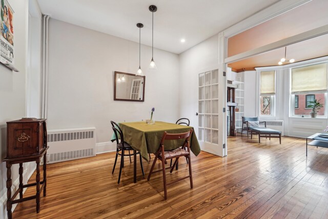 dining room with recessed lighting, radiator, and hardwood / wood-style flooring