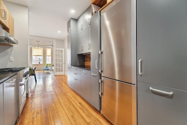 kitchen featuring light wood-type flooring, modern cabinets, dark countertops, recessed lighting, and stainless steel appliances