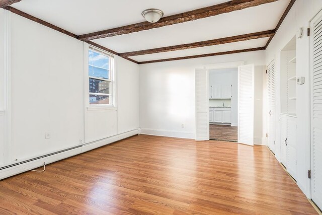 148 S St, Jersey City, NJ 07307 - unfurnished room featuring a baseboard radiator, light wood-style flooring, and beam ceiling