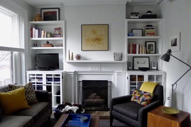 living room with built in shelves and a fireplace