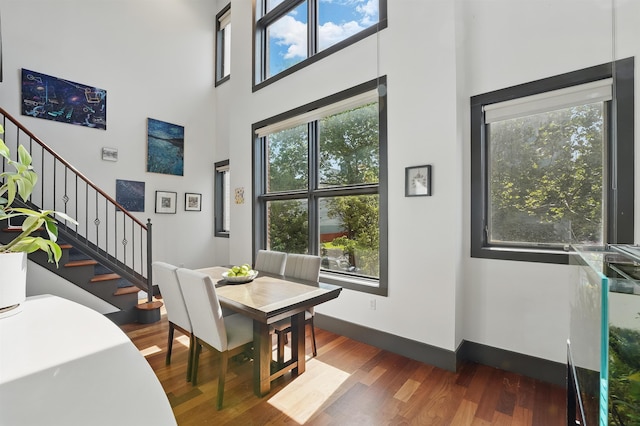 245 Ogden Ave Unit 2, Jersey City, NJ 07307 - dining room featuring a towering ceiling, wood finished floors, stairs, plenty of natural light, and baseboards