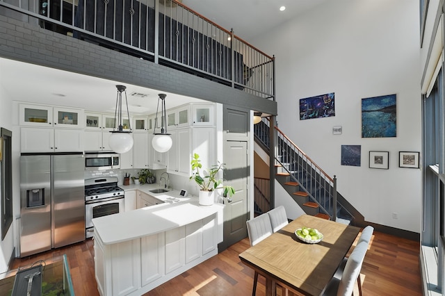 245 Ogden Ave Unit 2, Jersey City, NJ 07307 - kitchen featuring stainless steel appliances, a sink, a peninsula, dark wood finished floors, and white cabinets