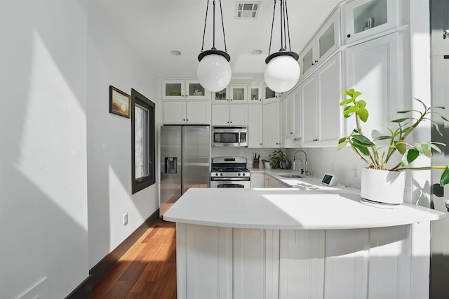245 Ogden Ave Unit 2, Jersey City, NJ 07307 - kitchen with stainless steel appliances, a sink, a peninsula, light countertops, and white cabinets