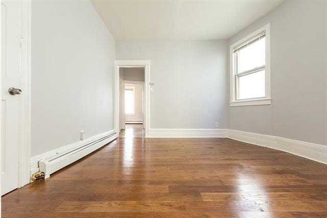 198 Myrtle Ave, Jersey City, NJ 07305 - empty room with a baseboard radiator and wood finished floors