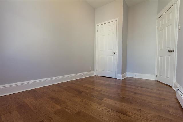198 Myrtle Ave, Jersey City, NJ 07305 - unfurnished bedroom with dark wood-style floors and a baseboard radiator
