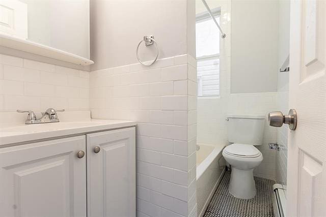 198 Myrtle Ave, Jersey City, NJ 07305 - bathroom featuring tile walls, baseboard heating, vanity, a wainscoted wall, and tile patterned flooring