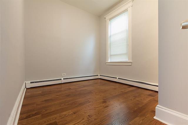 198 Myrtle Ave, Jersey City, NJ 07305 - unfurnished room with wood finished floors, a baseboard radiator, and lofted ceiling