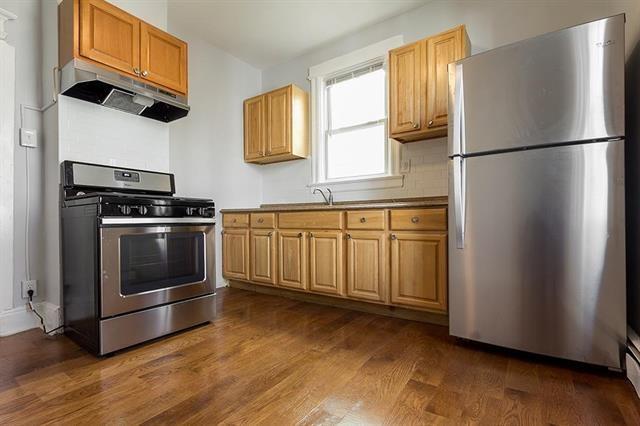 198 Myrtle Ave, Jersey City, NJ 07305 - kitchen with stainless steel appliances, under cabinet range hood, and dark wood-style flooring