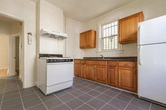 198 Myrtle Ave, Jersey City, NJ 07305 - kitchen featuring white appliances, dark tile patterned flooring, premium range hood, dark countertops, and brown cabinets