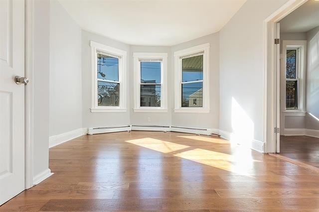 198 Myrtle Ave, Jersey City, NJ 07305 - spare room featuring wood finished floors and a baseboard radiator