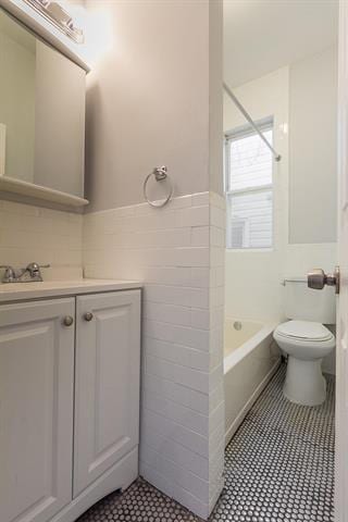 198 Myrtle Ave, Jersey City, NJ 07305 - bathroom with tile walls, vanity, tile patterned flooring, bathtub / shower combination, and a wainscoted wall