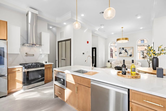 kitchen featuring sink, hanging light fixtures, stainless steel appliances, light stone countertops, and wall chimney range hood