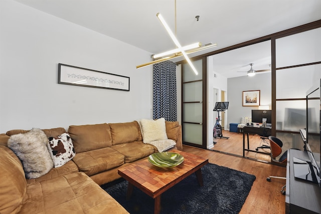living area with a ceiling fan and wood finished floors
