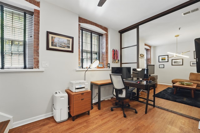 office area with wood finished floors, visible vents, and a wealth of natural light