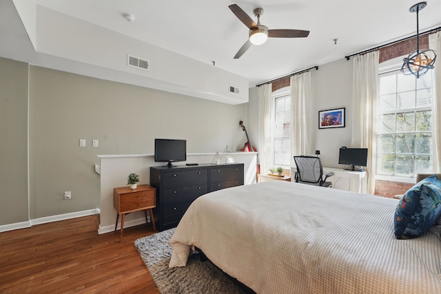 bedroom with visible vents, baseboards, wood finished floors, and ceiling fan