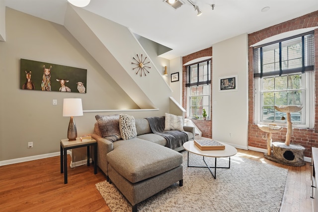 living area with rail lighting, baseboards, and wood finished floors