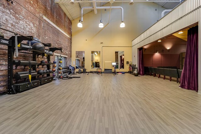 workout area with wood finished floors and high vaulted ceiling