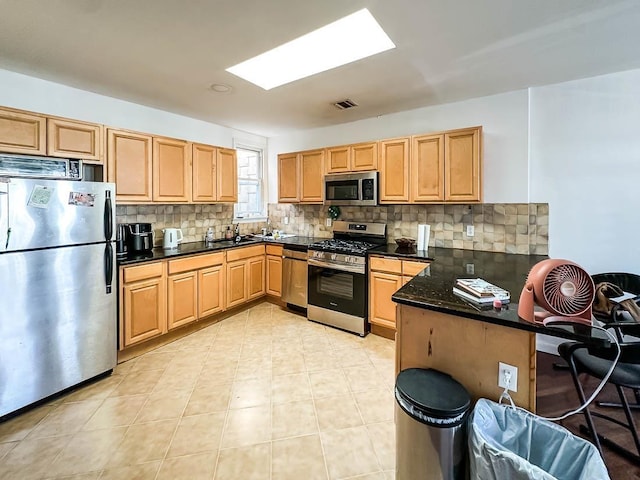 3481 John F Kennedy Blvd Unit 301, Jersey City, NJ 07307 - kitchen with appliances with stainless steel finishes, decorative backsplash, a peninsula, and light brown cabinets