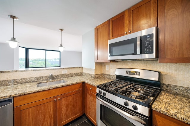 kitchen featuring appliances with stainless steel finishes, brown cabinetry, a sink, and decorative backsplash