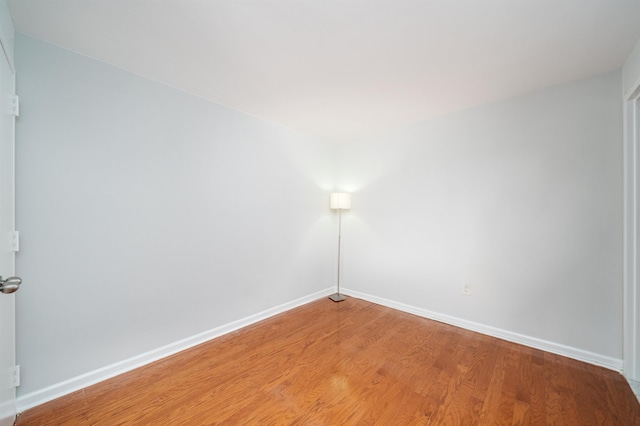 spare room featuring light wood finished floors and baseboards