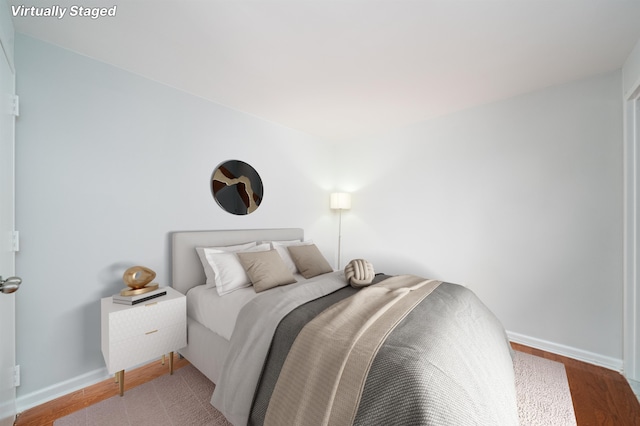 bedroom featuring wood finished floors and baseboards