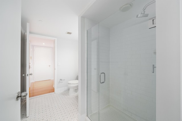 full bath featuring a stall shower, baseboards, visible vents, toilet, and tile patterned floors