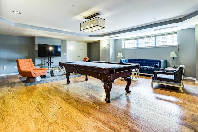 recreation room featuring billiards, a raised ceiling, wood finished floors, and baseboards