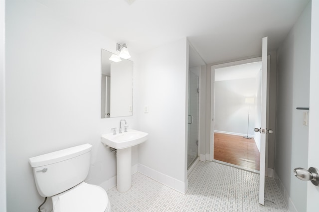 bathroom featuring baseboards, a shower stall, toilet, and tile patterned floors