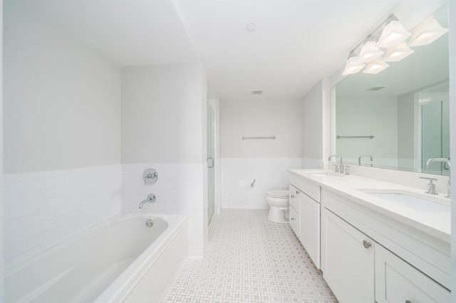 bathroom with toilet, double vanity, a sink, and a bath